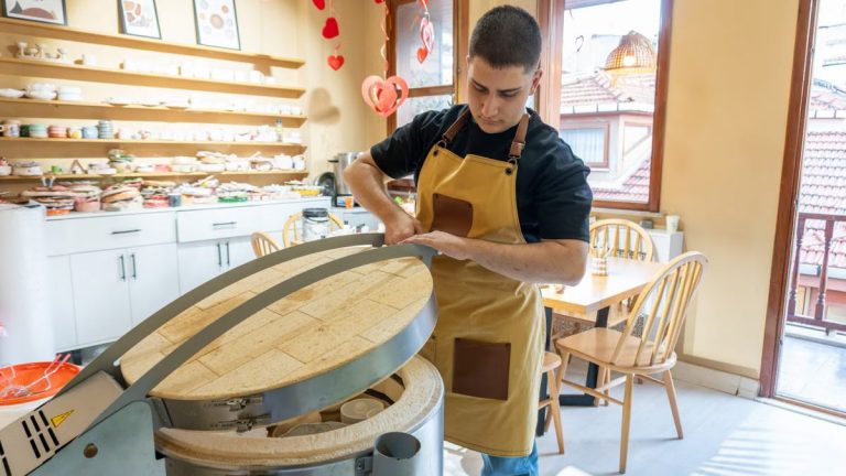 Baker in an apron preparing dough in a bakery with a warm, inviting atmosphere. Perfect representation of artisanal baking.
