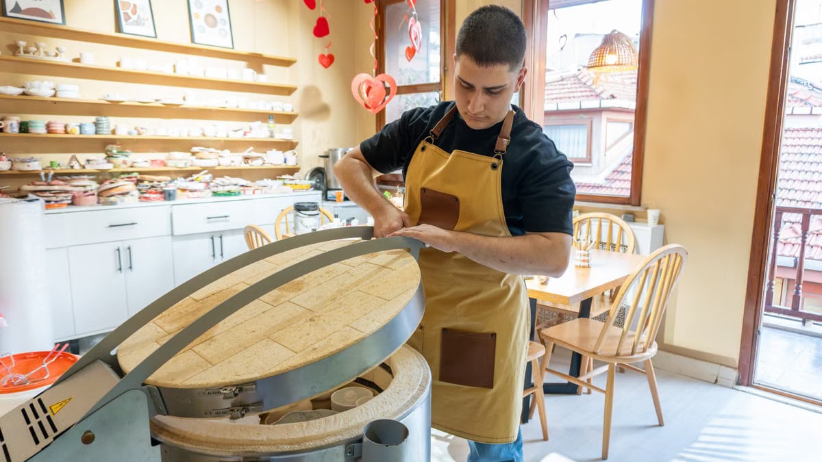 Baker in an apron preparing dough in a bakery with a warm, inviting atmosphere. Perfect representation of artisanal baking.
